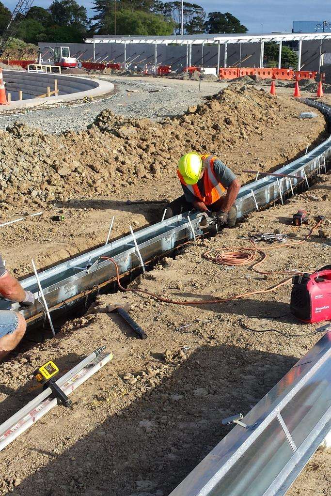 Positioning three metre sections to create a curve. Note how the positioning rods have been driven into the ground on an angle which induces tension when the THUNDAFLO is raised to the correct height. Each section was welded together to create the curve. If the THUNDAFLO is positioned in a straight line then it is not necessary to weld the sections together.  
